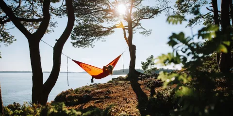 Kvinde i hængekøje med udsigt over en fjord